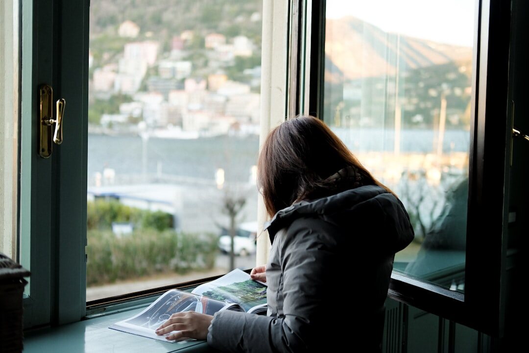 person reading book by window